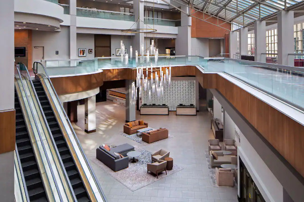 Escalators ascend in a modern atrium-style hotel lobby.