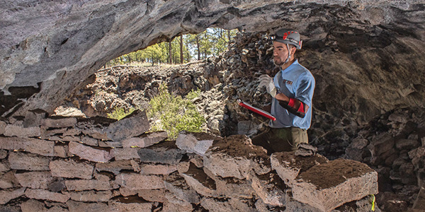 A man records observations in a cave.